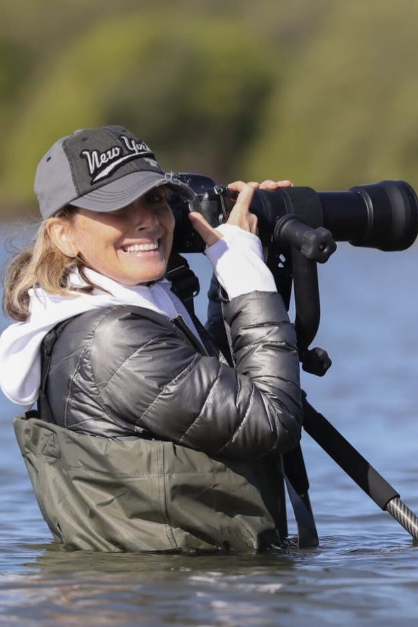 Maria Zdroik - waders on, camera equipment precariously balanced, standing chest-deep in Tampa Bay's warm waters
